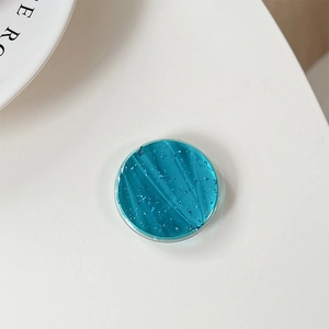 Detailed macro view of a round blue glitter phone grip with faceted crystal texture