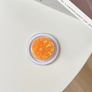 Macro detail of heart-shaped orange glitter sequins for phone case DIY craft