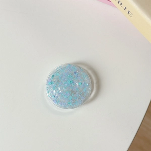 Détail d'un support de téléphone rond avec des paillettes irisées bleues et mauves