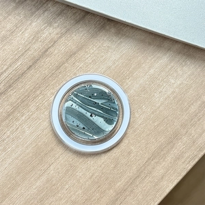 Dettaglio supporto magnetico per telefono con motivo marmo verde e lamina d'argento