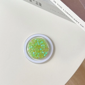 Close-up of magnetic phone grip with iridescent light green heart-shaped sequins inside