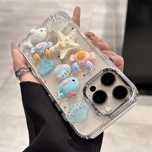 Close-up of 3D ocean charms with starfish and whale on a glittery iPhone case