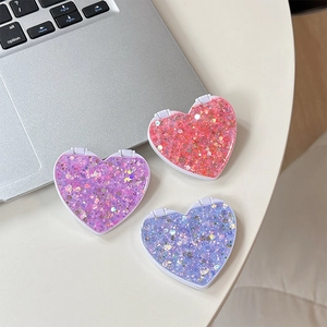 Close-up of glittery heart-shaped folding mirrors in pink, purple, and blue colors