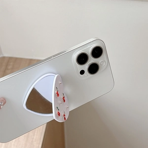 Detail of heart-shaped phone mirror socket with cherry design on a white smartphone