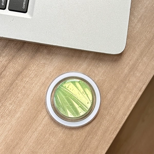 Dettaglio del supporto MagSafe per telefono con trama artistica verde e gialla