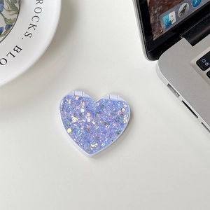 Macro detail of purple glitter heart folding phone mirror with sparkling sequins finish