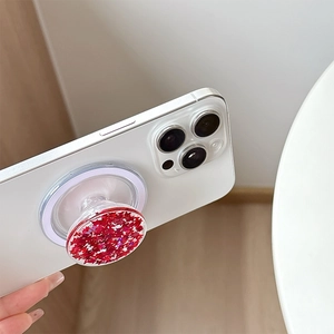 Detail of red star sequin magnetic phone socket holder on white iPhone Pro model