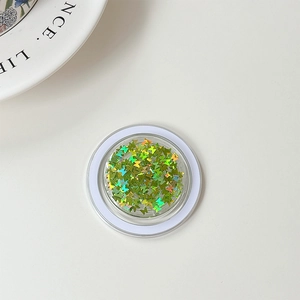 Close-up of holographic green butterfly sequins for nail art in a transparent round case