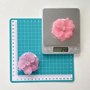 Gros plan du support de téléphone fleur rose montrant 5,5 cm de diamètre et 24,8 g