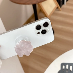 Close-up of a 3D cat paw phone socket in soft pink on a white smartphone back