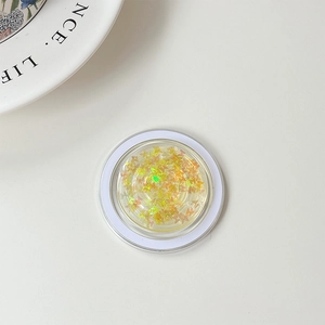 Macro detail of a round phone grip featuring sparkling laser butterfly sequins in golden hues