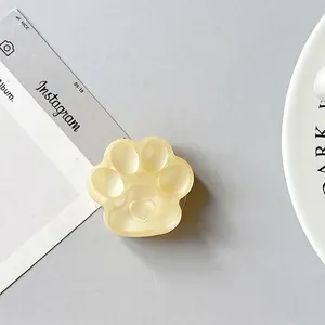 Macro detail of a translucent yellow 3D cat paw phone socket with embossed heart design