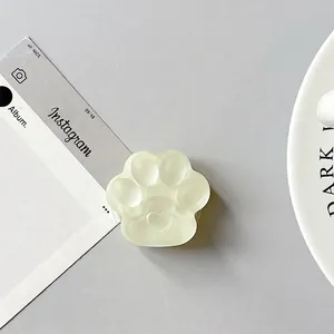 Close-up of translucent cat paw phone grip with a heart detail and smooth silicone texture