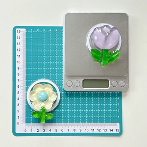Détail du support de téléphone en acrylique motif tulipe et fleur mesurant 5 cm