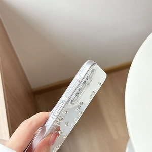 Detail view of transparent phone case side buttons and 3D silver bear decoration