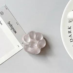 Detailed view of pink translucent cat paw phone grip with 3D heart-shaped pad detail