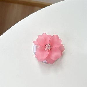 Détail d'un support de téléphone fleur rose mat avec pétales en résine et perles