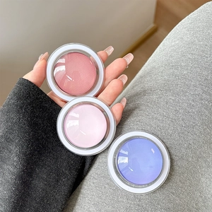 Detail of round magnetic makeup cases with transparent lids on grey fabric background