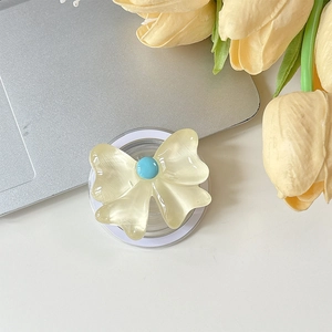 Détail d'un support de téléphone nœud jaune élégant avec perle bleue sur blanc