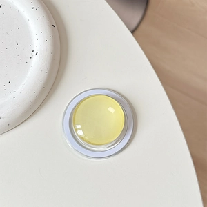 Top view of yellow crystal glass magnetic phone holder on minimalist white background