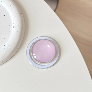 Top view of a round crystal glass Magsafe phone grip with pink and purple center
