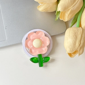 Gros plan d'un support de téléphone en fleur rose avec résine brillante sur bureau