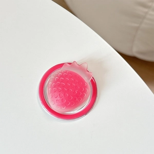 Close-up of pink 3D strawberry magnetic phone grip with semi-transparent texture and seeds