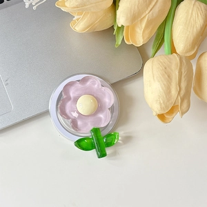 Détail du support de téléphone floral aux pétales roses transparents sur un ordinateur