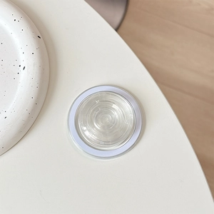 Macro shot of minimalist crystal glass magnetic phone grip base with white circular ring