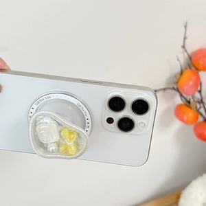 Detail of magnetic phone grip featuring resin bow, marble pattern and pearl accents
