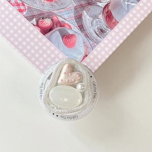Close-up of pink heart and pearl phone grip on a stylish checkered gift box background