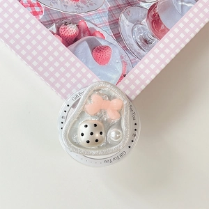 Detail of cute resin phone grip with pink bow, polka dot ball and pearl embellishments