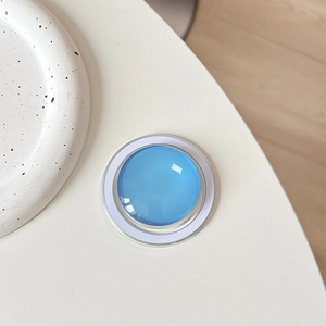 Detail of blue crystal glass magnetic phone grip with a minimalist white MagSafe base