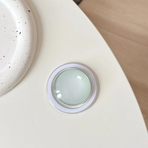 Detail of light green crystal glass MagSafe phone grip with minimalist round design