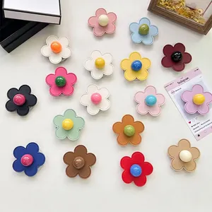 Flat lay of colorful floral phone grip sockets with leather texture and bead center