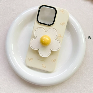 Detailed view of cream iPhone case with 3D flower grip and cute yellow bow patterns