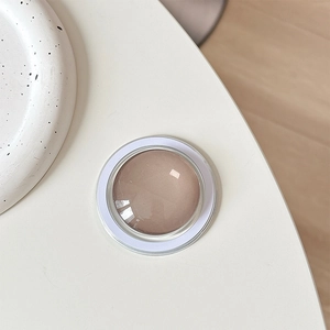 Top view of champagne gold domed magnetic phone grip on a white minimalist background