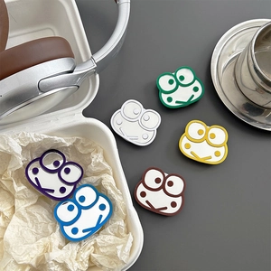 Close-up of colorful cartoon frog pins set in purple blue white green yellow and brown