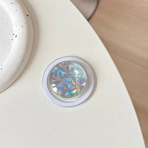 Macro shot of circular Magsafe phone grip with holographic rainbow crystal texture surface