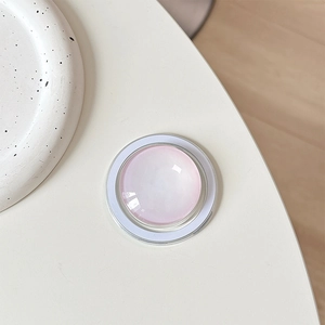 Detail of pink pearlescent magnetic phone socket on a minimalist ceramic plate