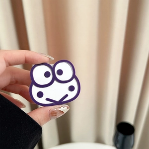 Close-up of a cute cartoon frog accessory held in hand to show its small size