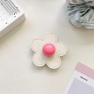 Close-up of a floral phone socket featuring a pink bead center and cream leather petals