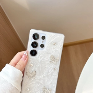 Detail of pearlescent white phone case with 3D glitter texture and diamond butterfly decor
