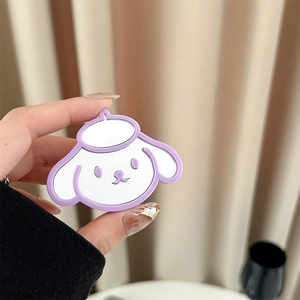 Gros plan d'un support de téléphone chiot de dessin animé violet tenu devant un rideau