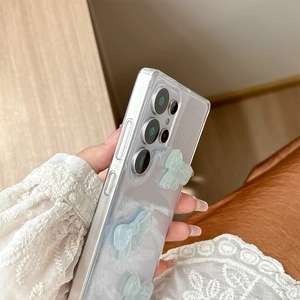 Detail shot of transparent glitter phone case with three 3D light blue resin bows