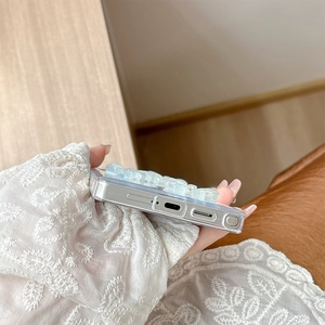 Close-up of clear phone case with blue 3D bear decoration and precise port cutouts