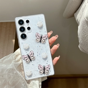 Detailed macro view of 3D butterfly and white rose decorations on glitter phone case