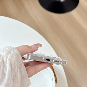 Detail showing precise charging port cutouts on a glitter bow phone case for Samsung