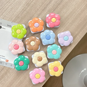 Colorful floral phone grips with mirrors in macaron colors on a light wood table