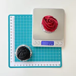 Macro view of magnetic camellia flower phone holder with rhinestones and fabric texture